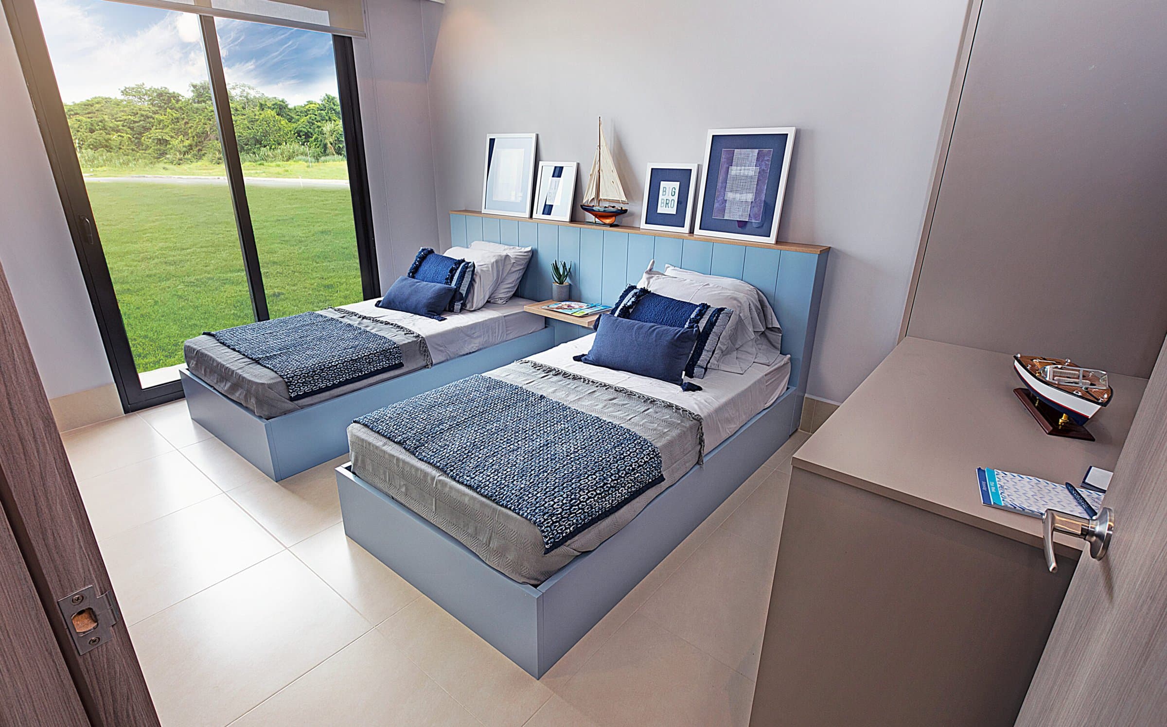 Bedroom with twin beds and ocean-side greenery at Ocean Villas