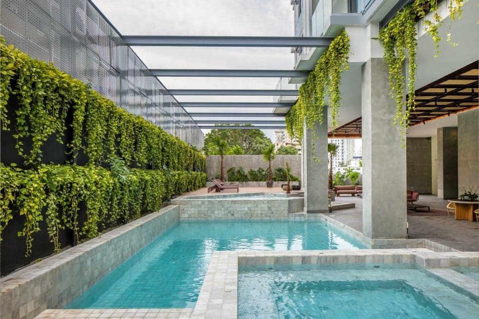 Velure pool and jacuzzi framed by green walls
