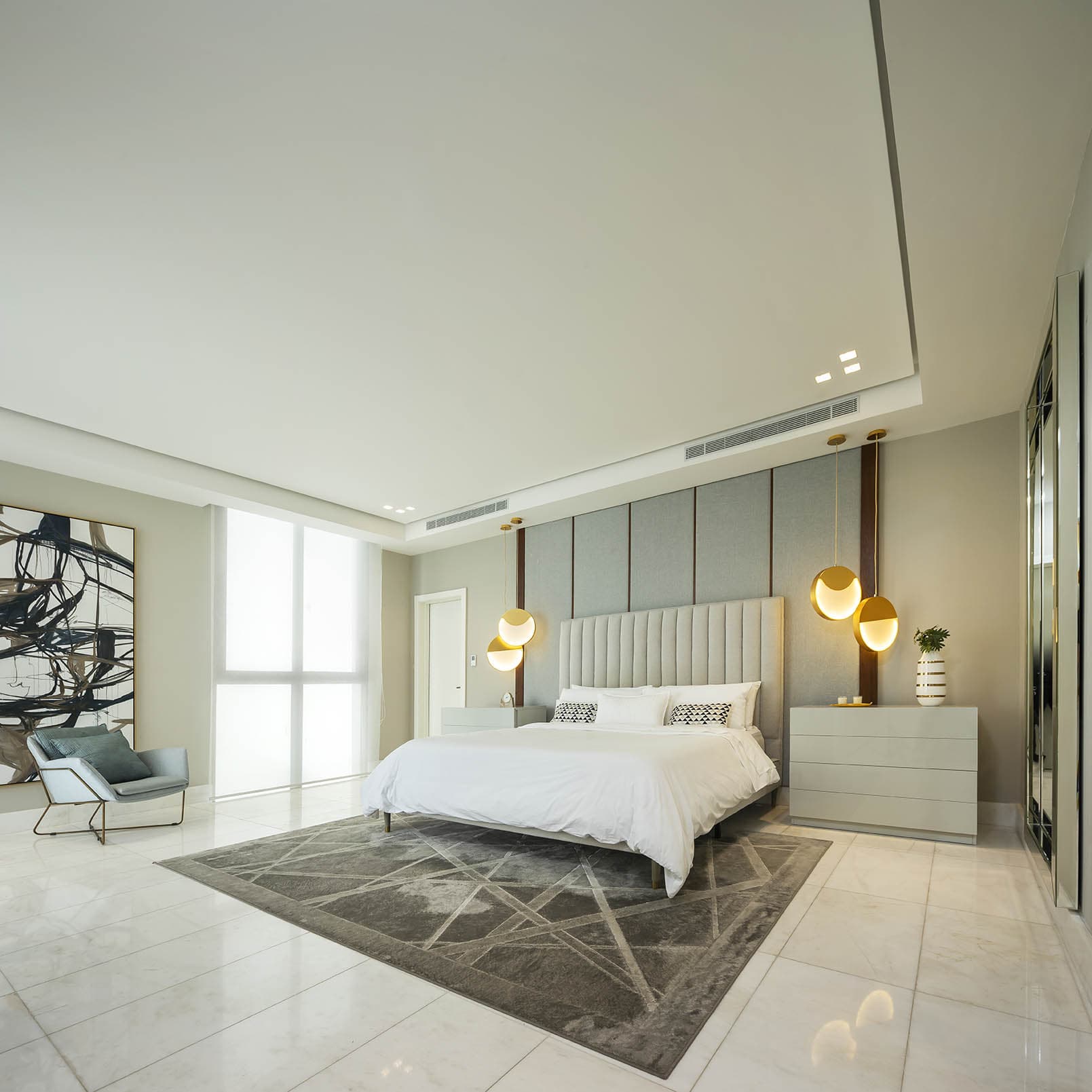 Master bedroom with an upholstered headboard at The Residences