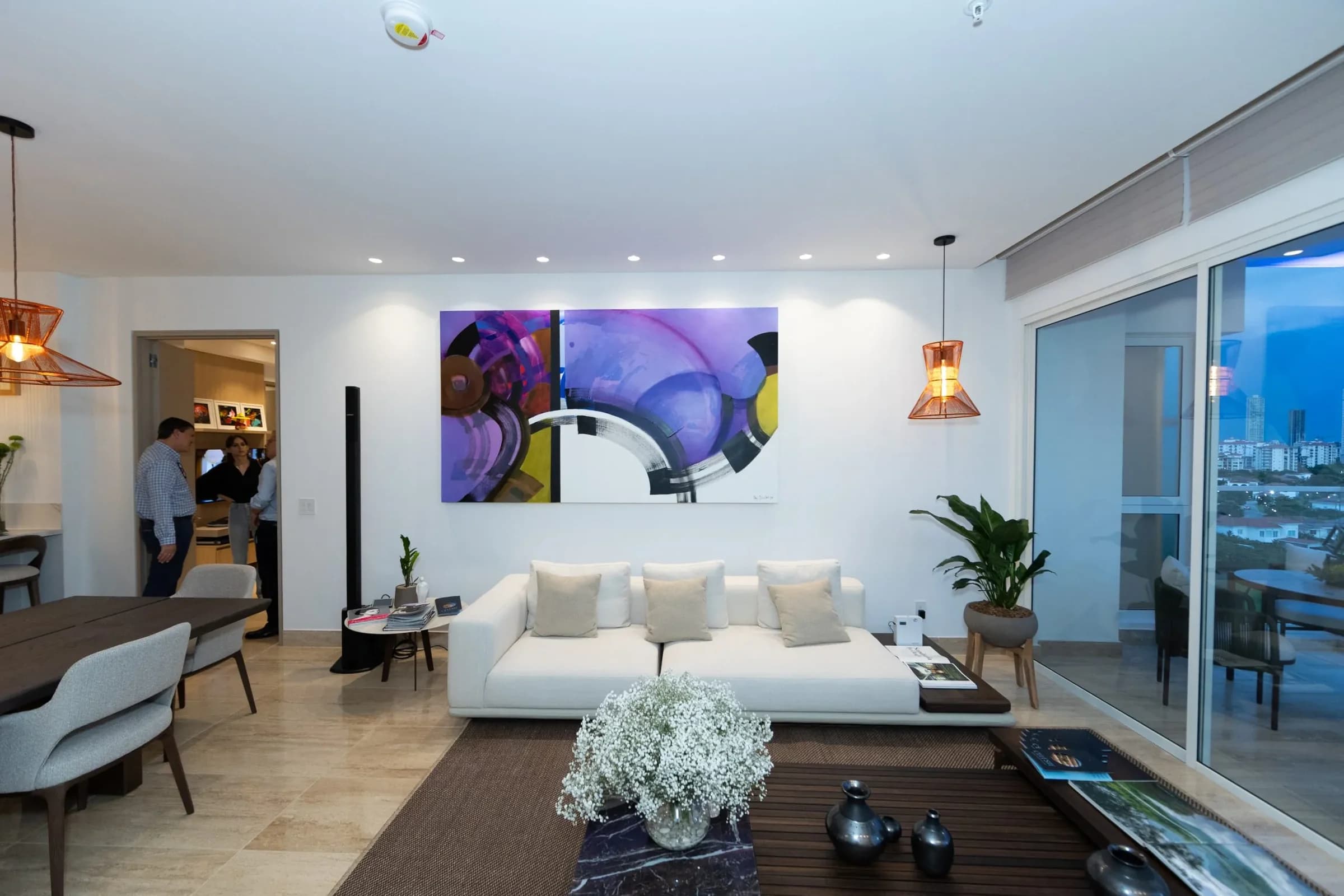 Furnished living room with balcony and city view in the Celeste model apartment