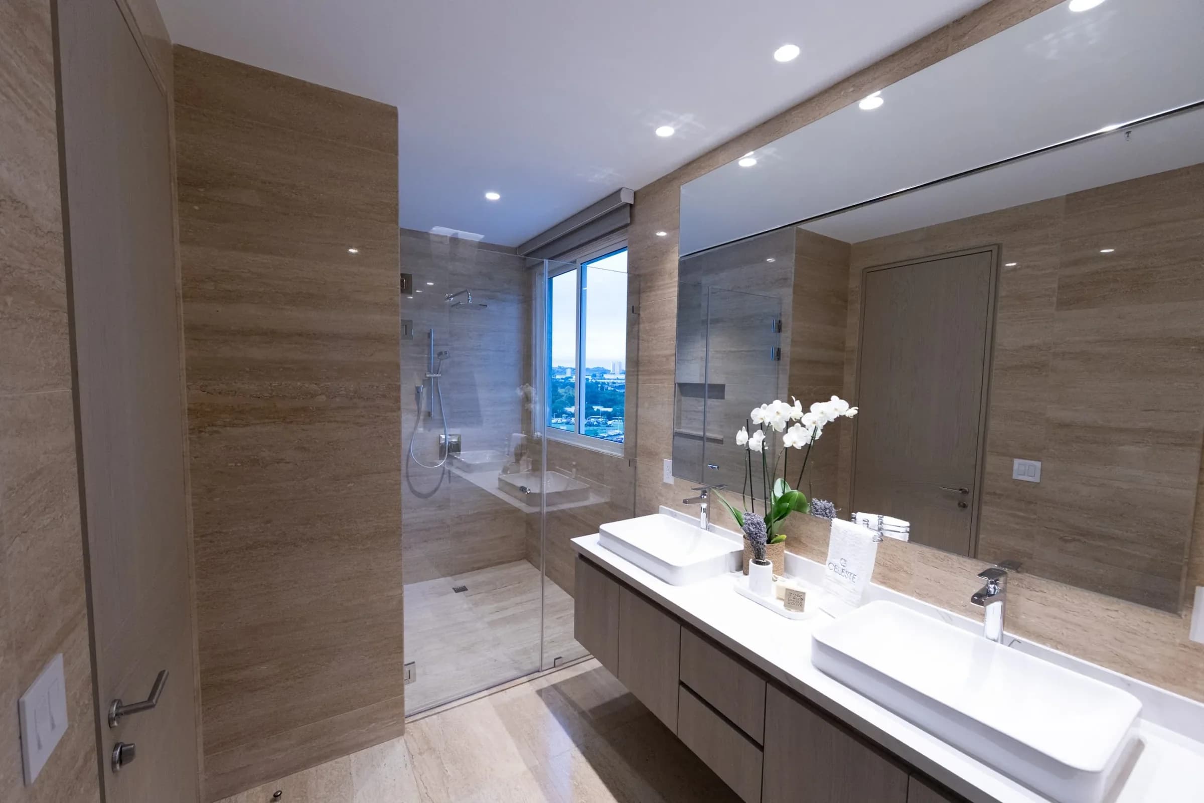 Bathroom with double vanity and glass shower in the Celeste model apartment