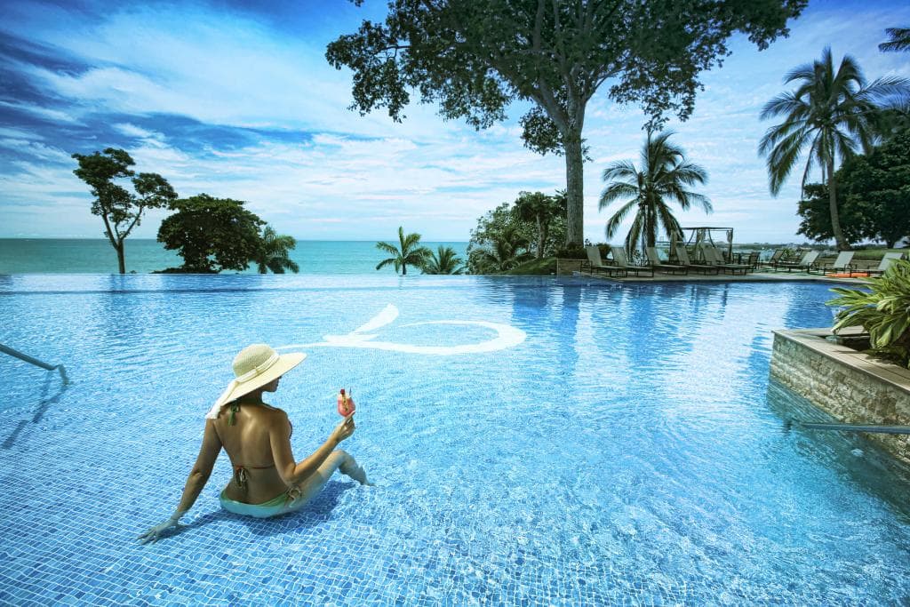 Infinity pool at Bahia framed by tropical trees and the Pacific