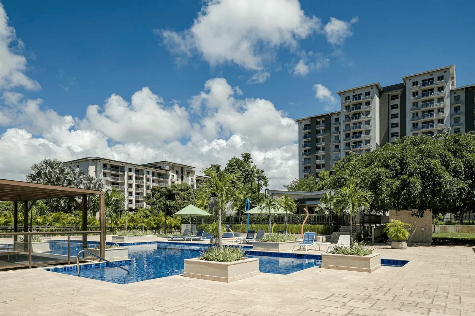 Parterre pool deck with loungers and the residential towers behind