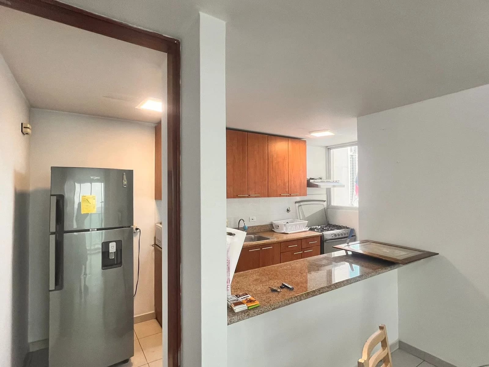Kitchen of a Terramar apartment with wood cabinets and stainless steel fridge