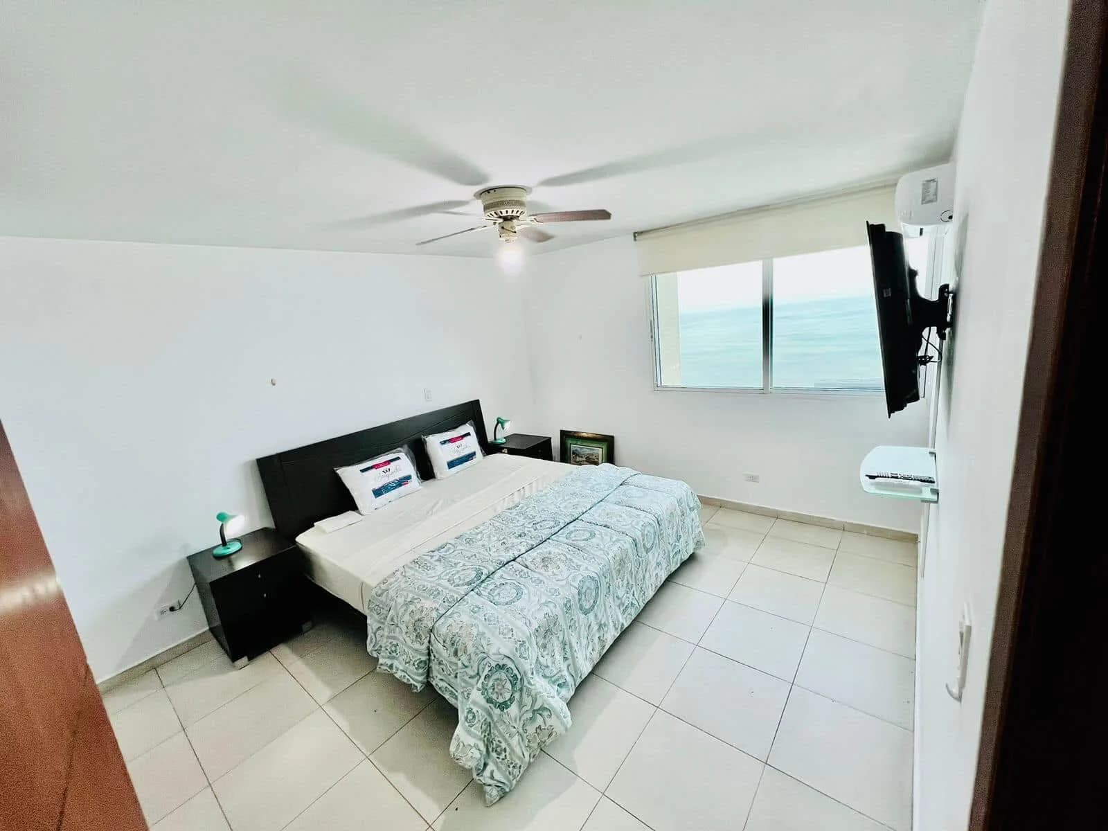 Bedroom of a Terramar apartment with a window over the ocean