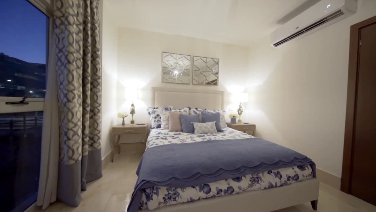 Bedroom with upholstered headboard and balcony window in an apartment at The Reserve, Santa Maria