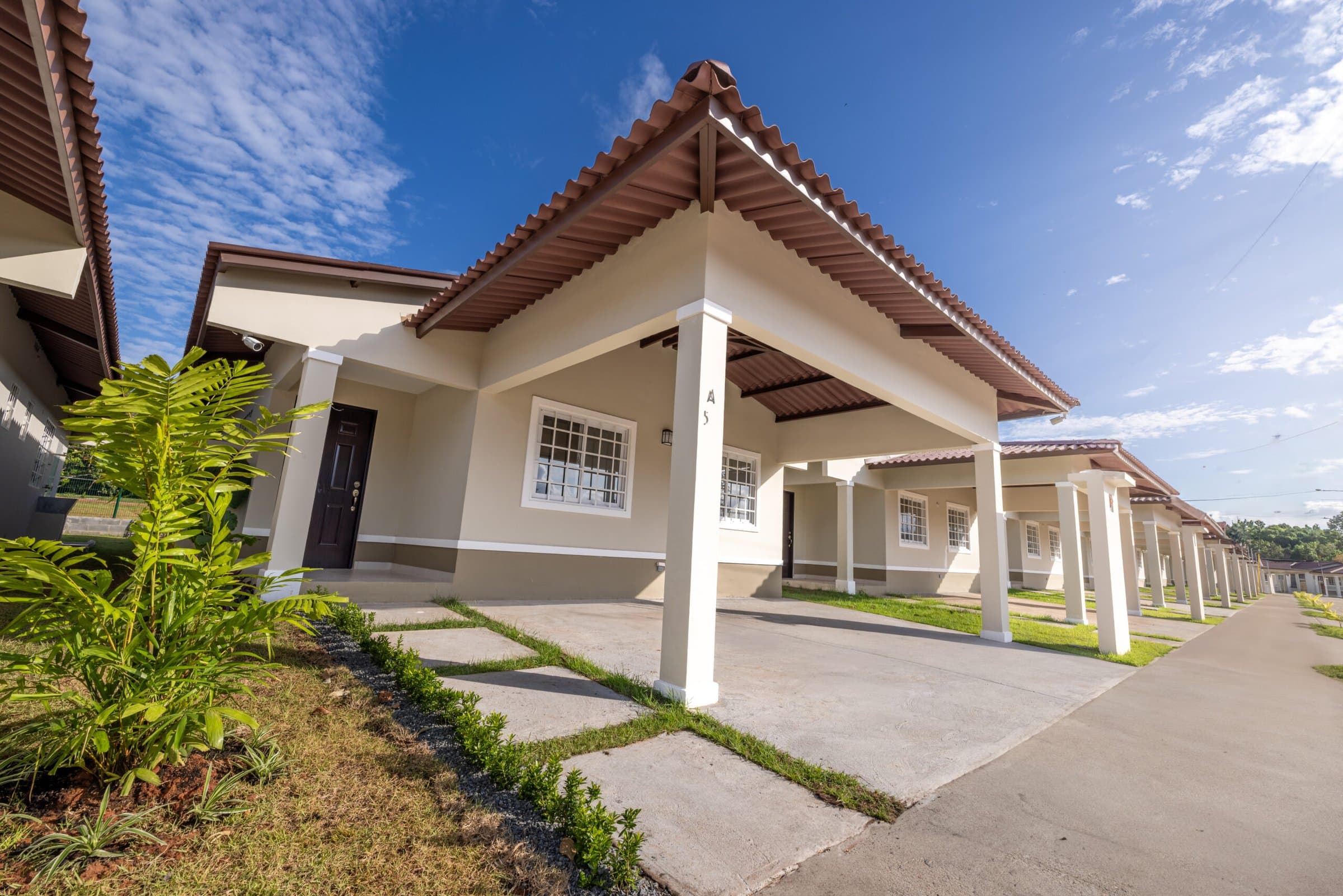 Row of finished houses along a landscaped street at Colonia Real