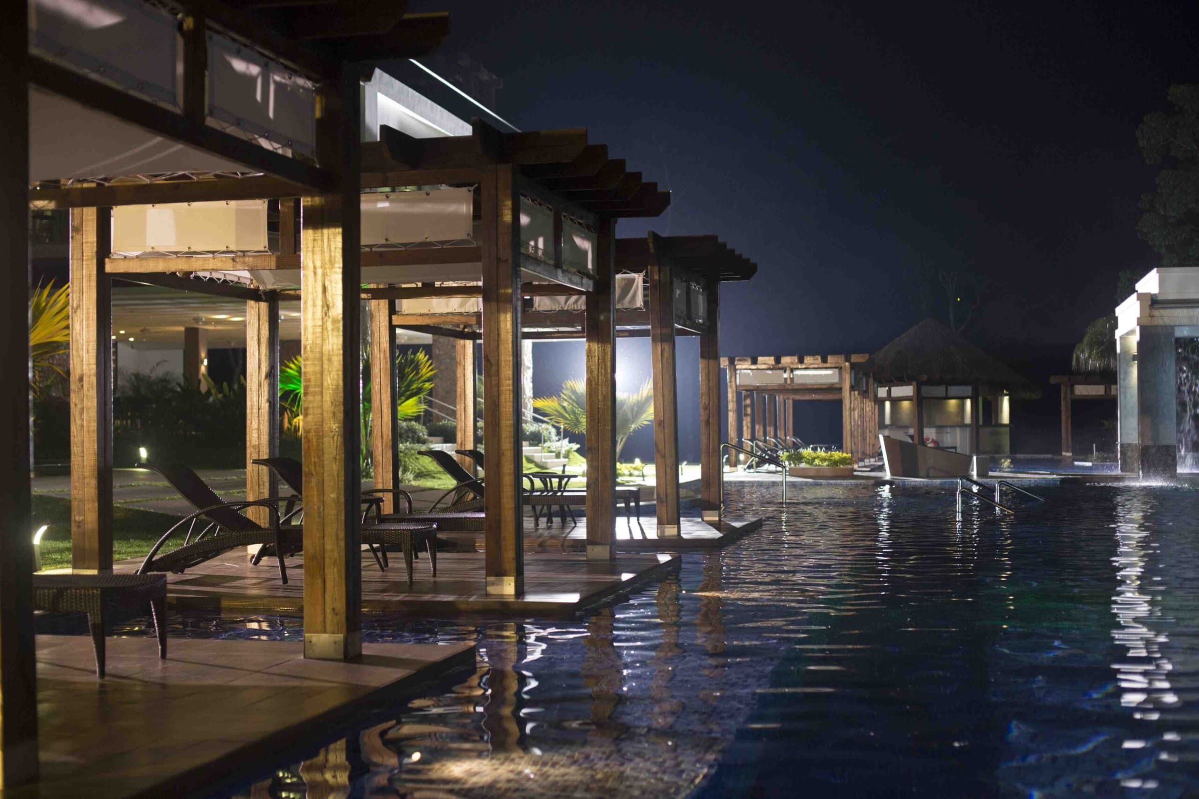 Pool pergolas lit at night at The Pearl Club, Playa Bonita