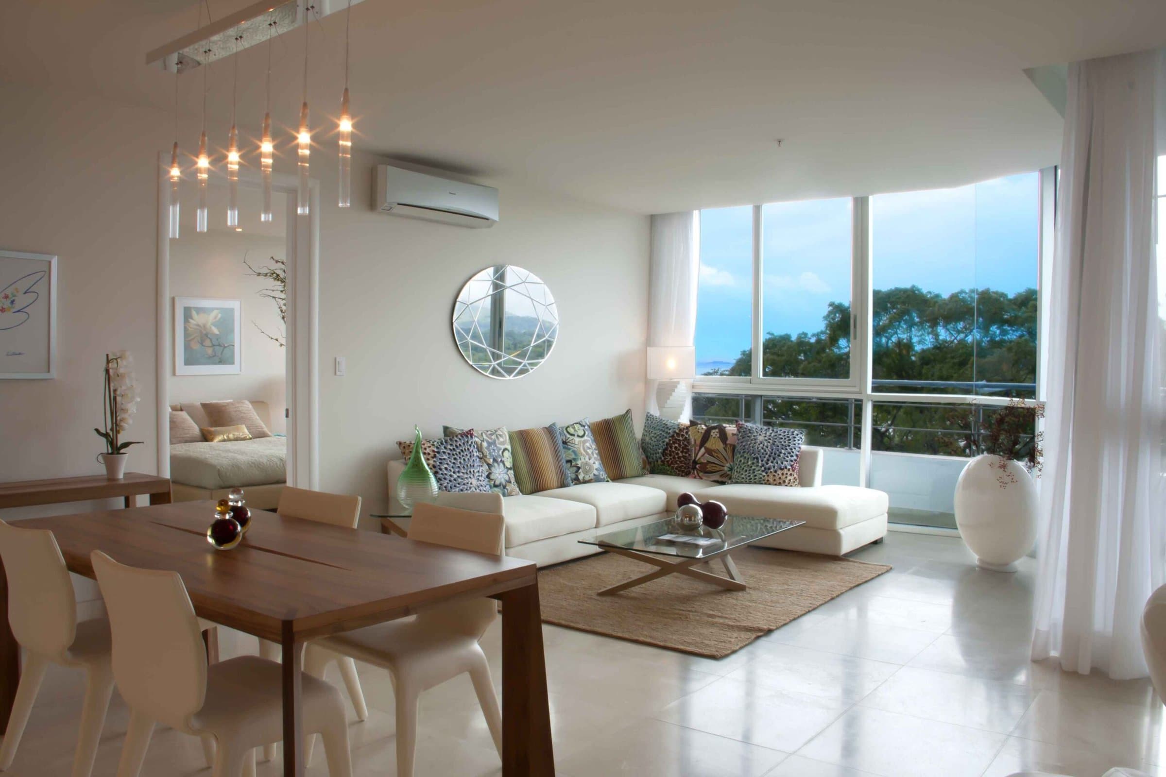 Living and dining room with ocean-side windows in a Casa Bonita apartment