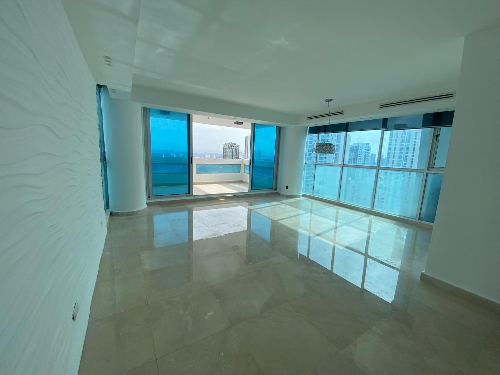 Bright living room with marble floors and glass balcony doors at PH The View, San Francisco, Panama City