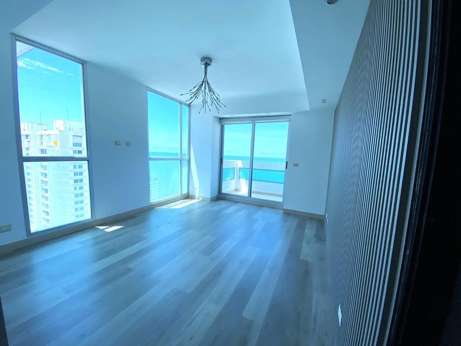 Bedroom with wood floors and corner windows over the sea at PH The View, San Francisco, Panama City