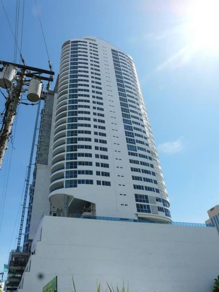 Street-level view of the rounded PH Joy Tower rising over San Francisco, Panama City