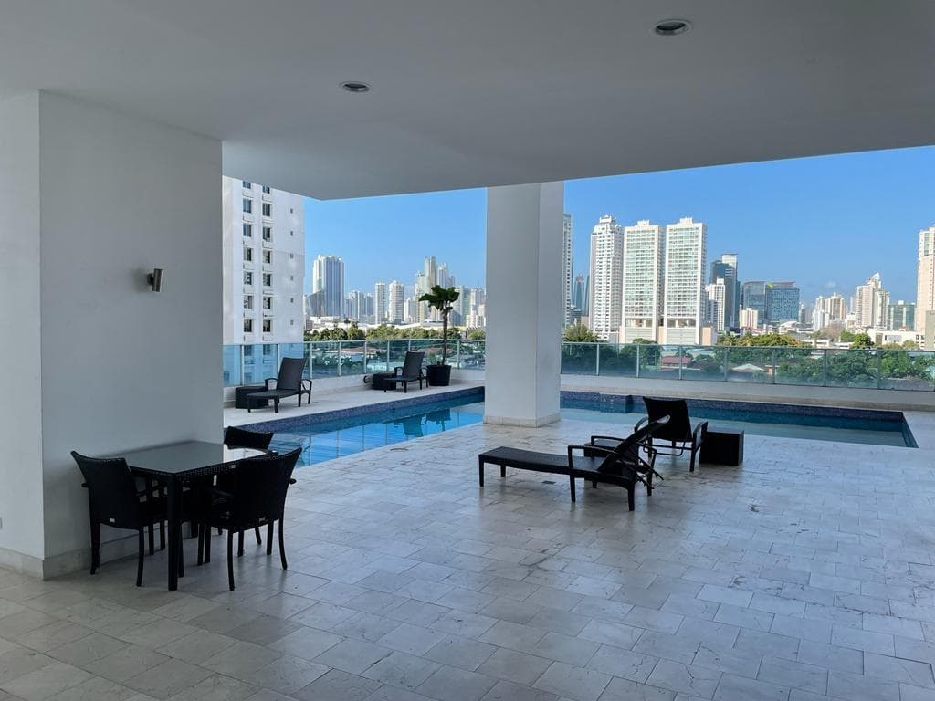 Covered pool terrace with dining table and city views at PH Joy Tower, San Francisco, Panama City