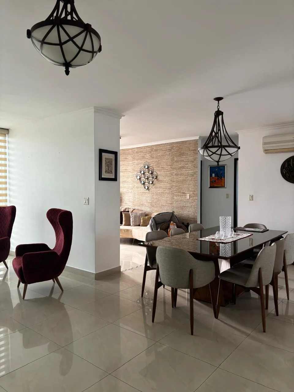 Dining area with pendant lamps and a stone accent wall in an apartment at PH Infinity, San Francisco, Panama City