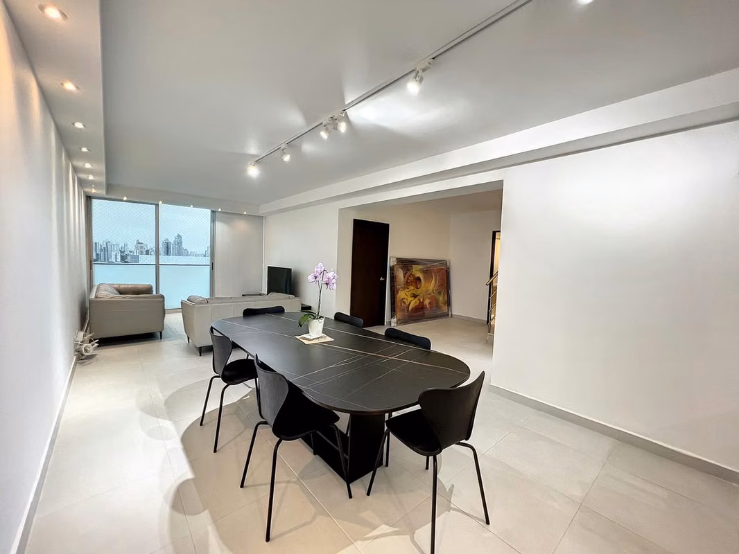 Open living and dining area with a long table in an apartment at PH Pacific Sky, Punta Paitilla, Panama City