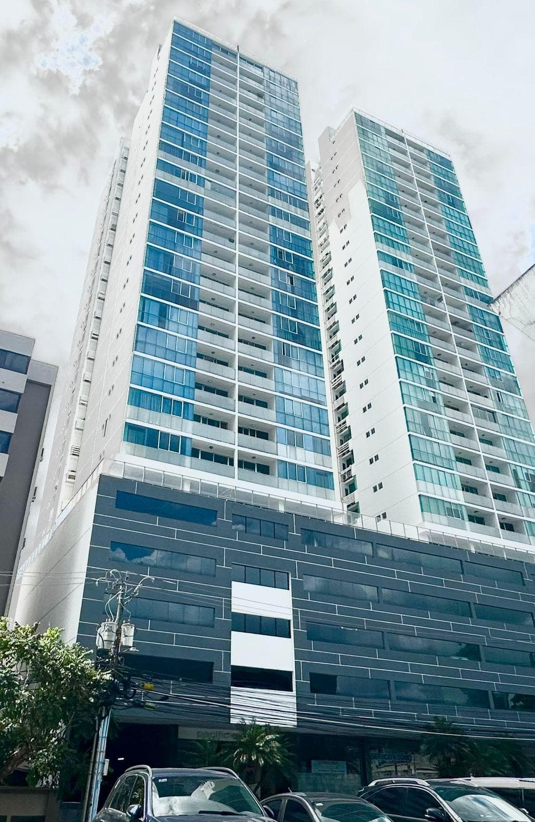 PH Pacific Sky twin residential towers with blue glass balconies above their dark tiled podium, Punta Paitilla, Panama City