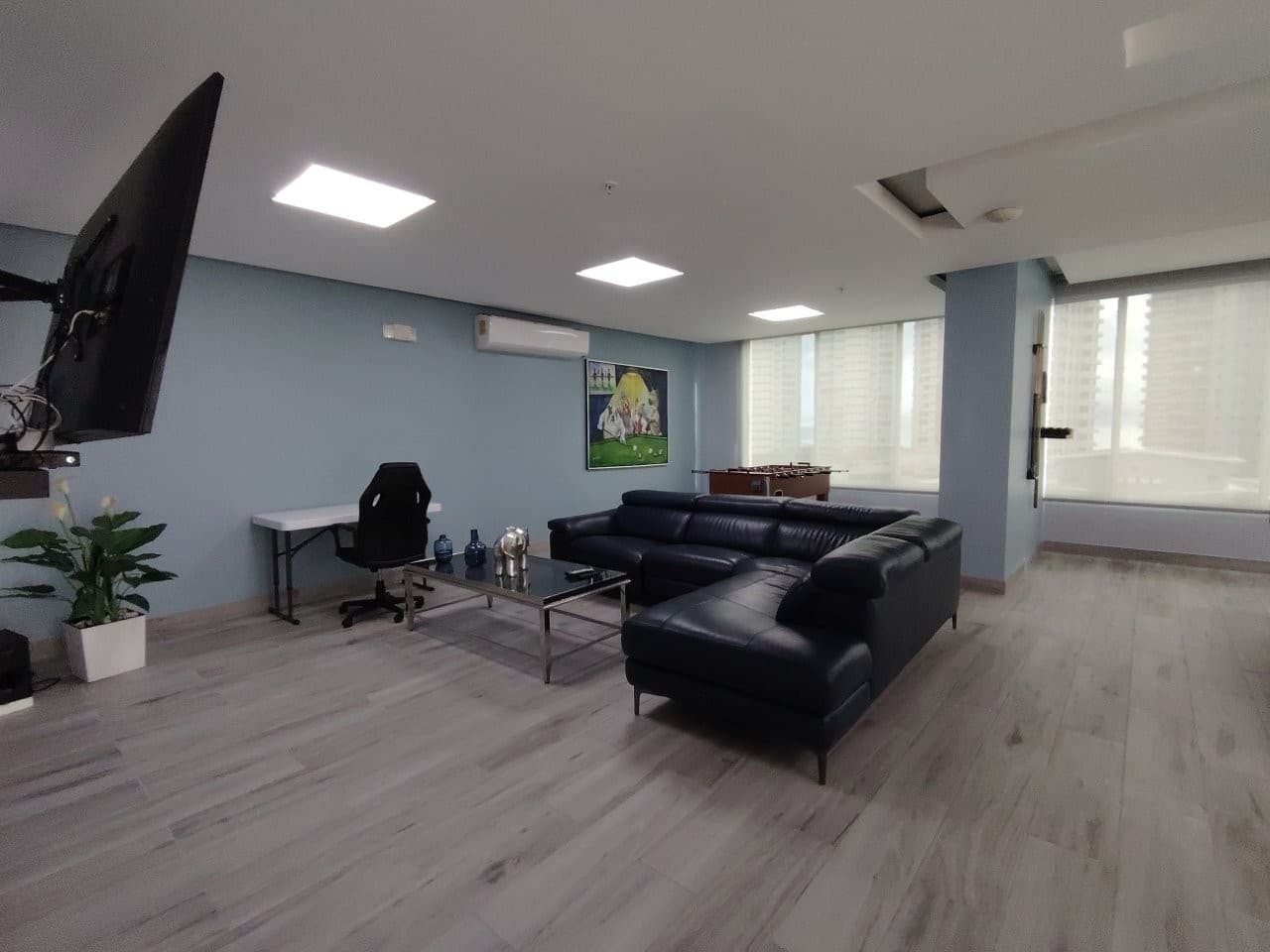 Living area with a leather sectional and bright windows at PH WaterView, San Francisco, Panama City