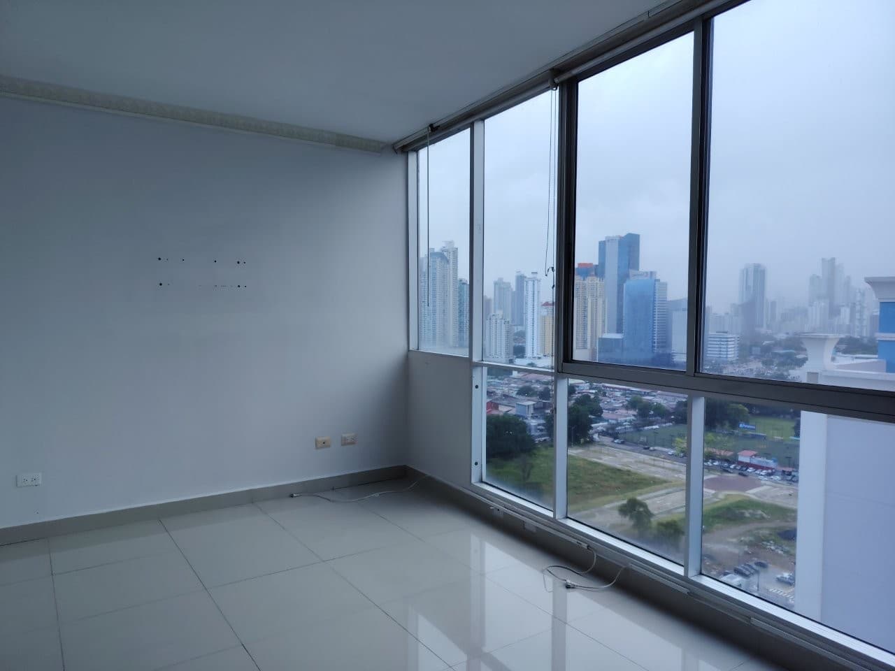 Empty living room with floor-to-ceiling windows and skyline views in an apartment at PH WaterView, San Francisco, Panama City