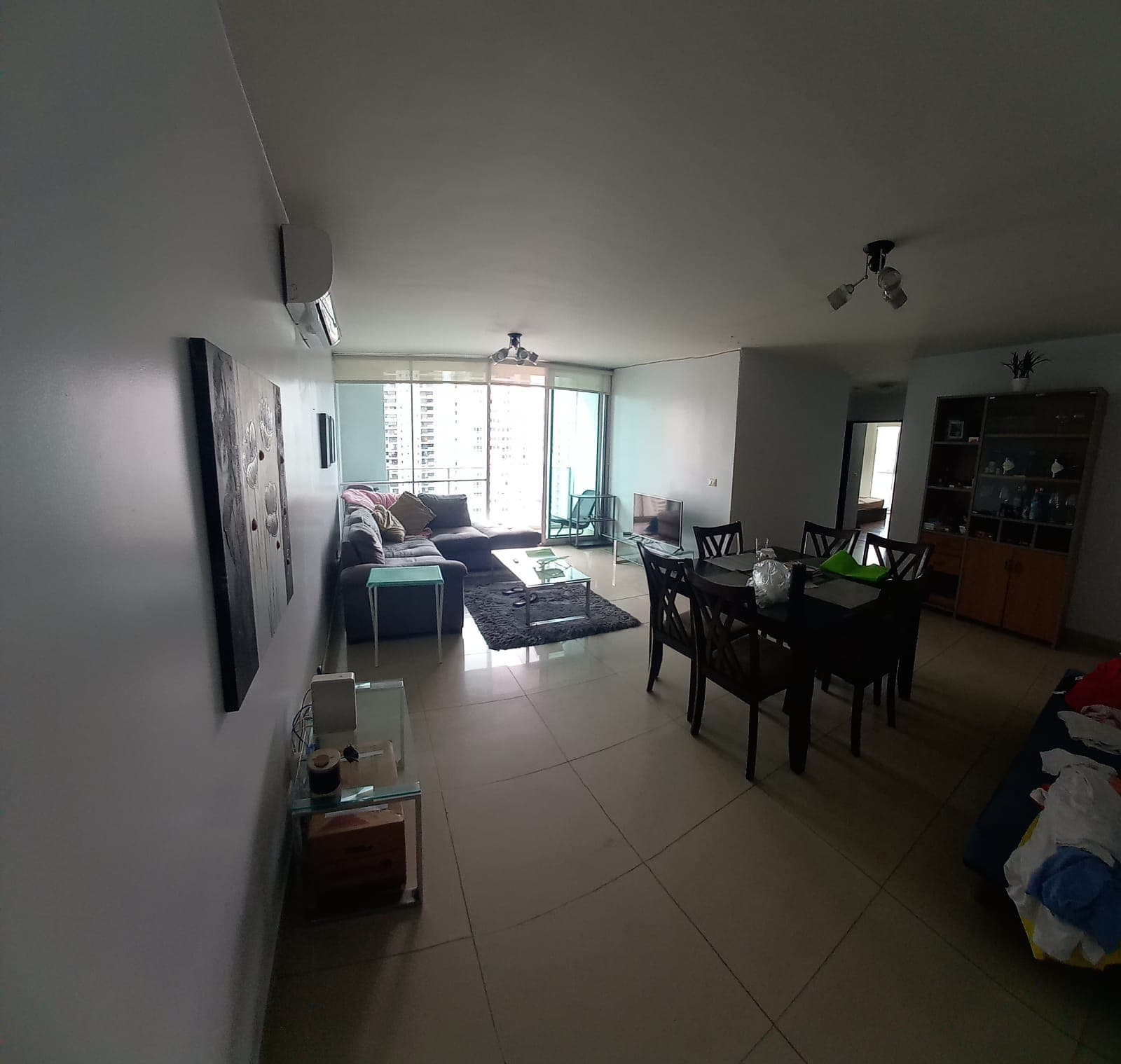 Living and dining area opening to a view of the city in an apartment at PH WaterView, San Francisco, Panama City
