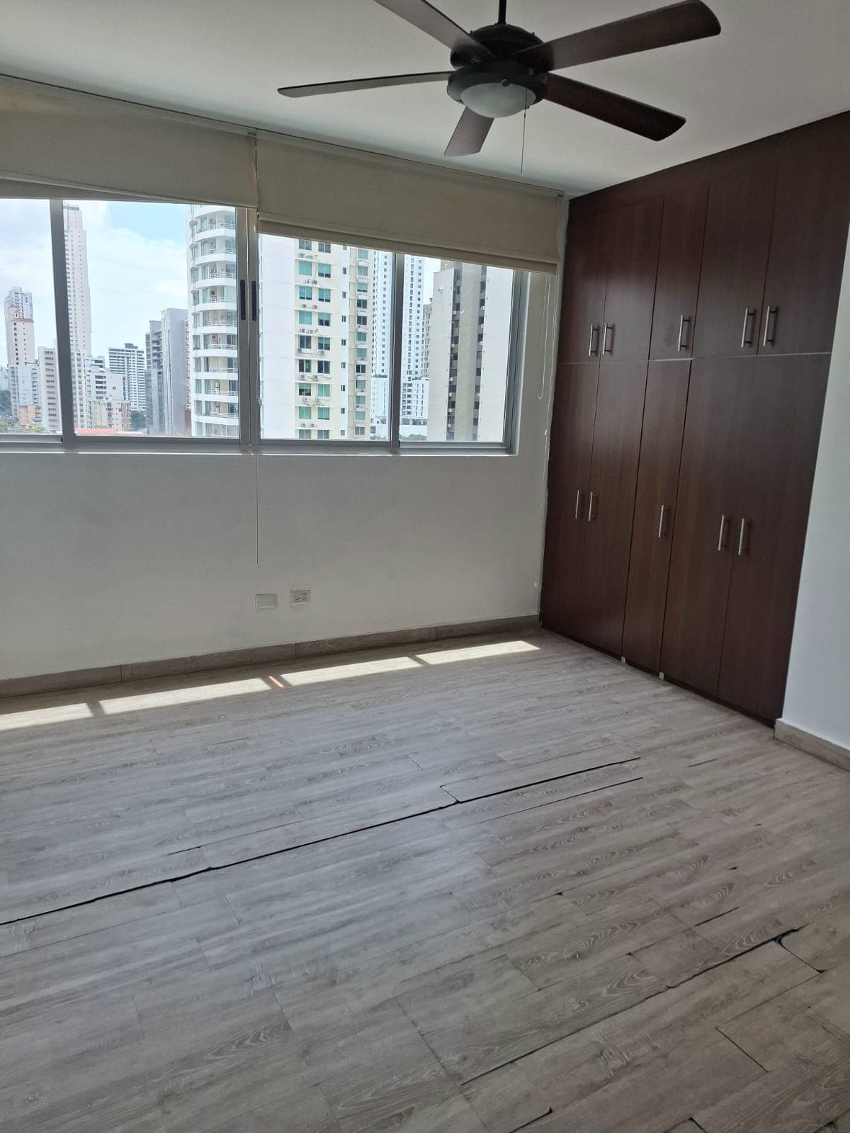 Bedroom with wood-look floors, built-in wardrobe and city views at Harmony Tower, San Francisco, Panama City