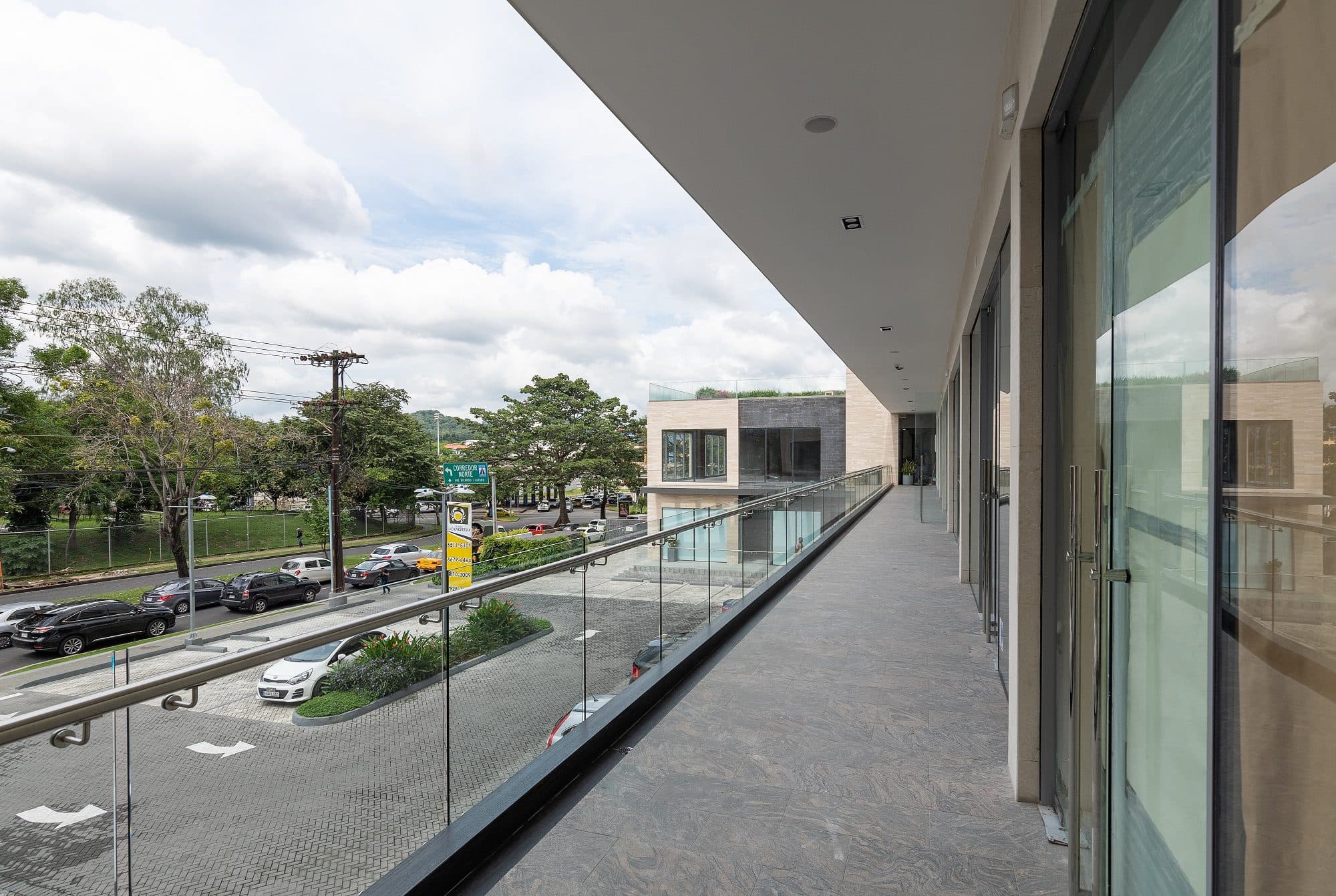 Upper-level retail corridor overlooking the parking at Plaza El Cangrejo