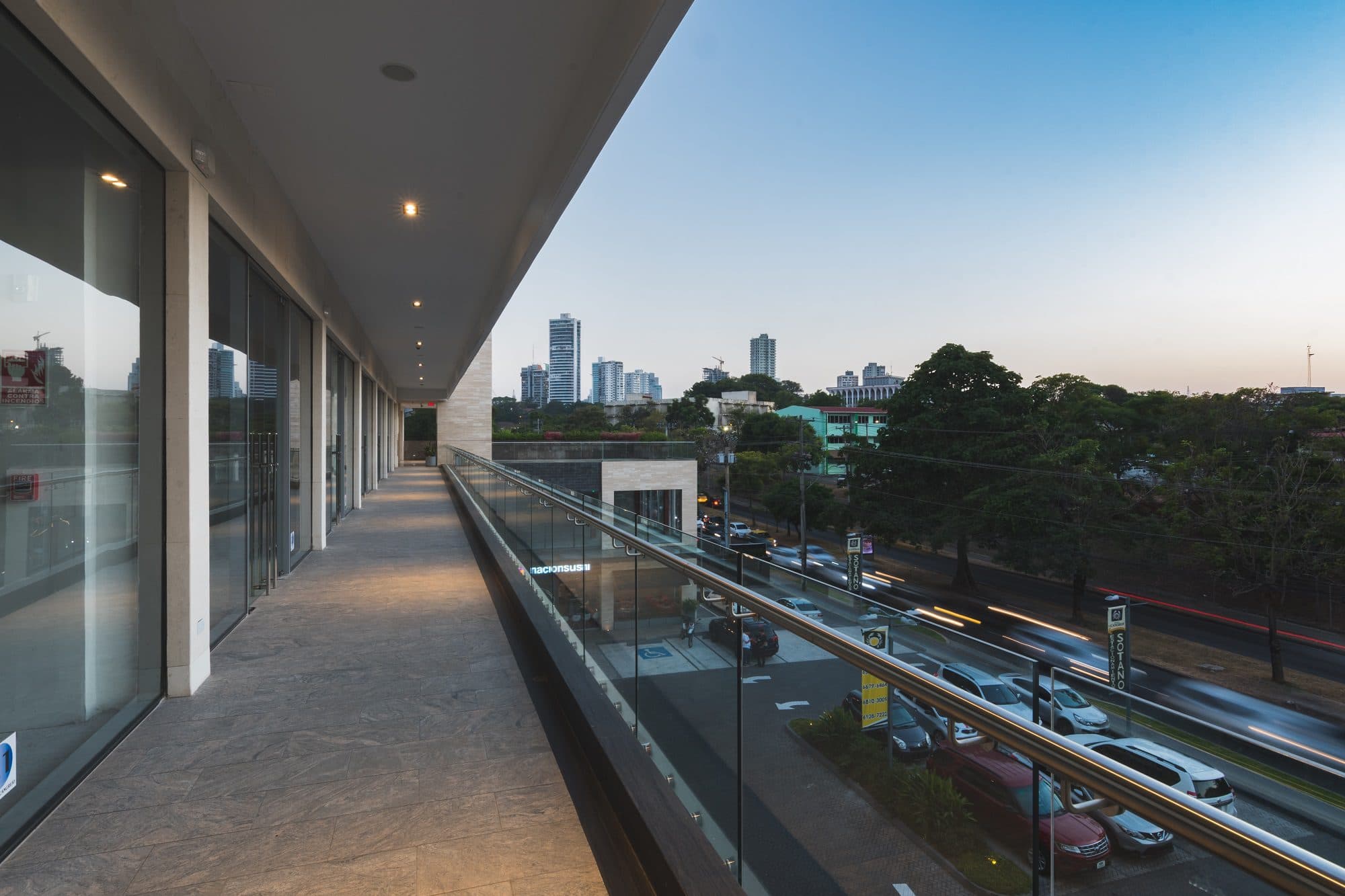 Upper-level walkway with a glass railing at Plaza El Cangrejo
