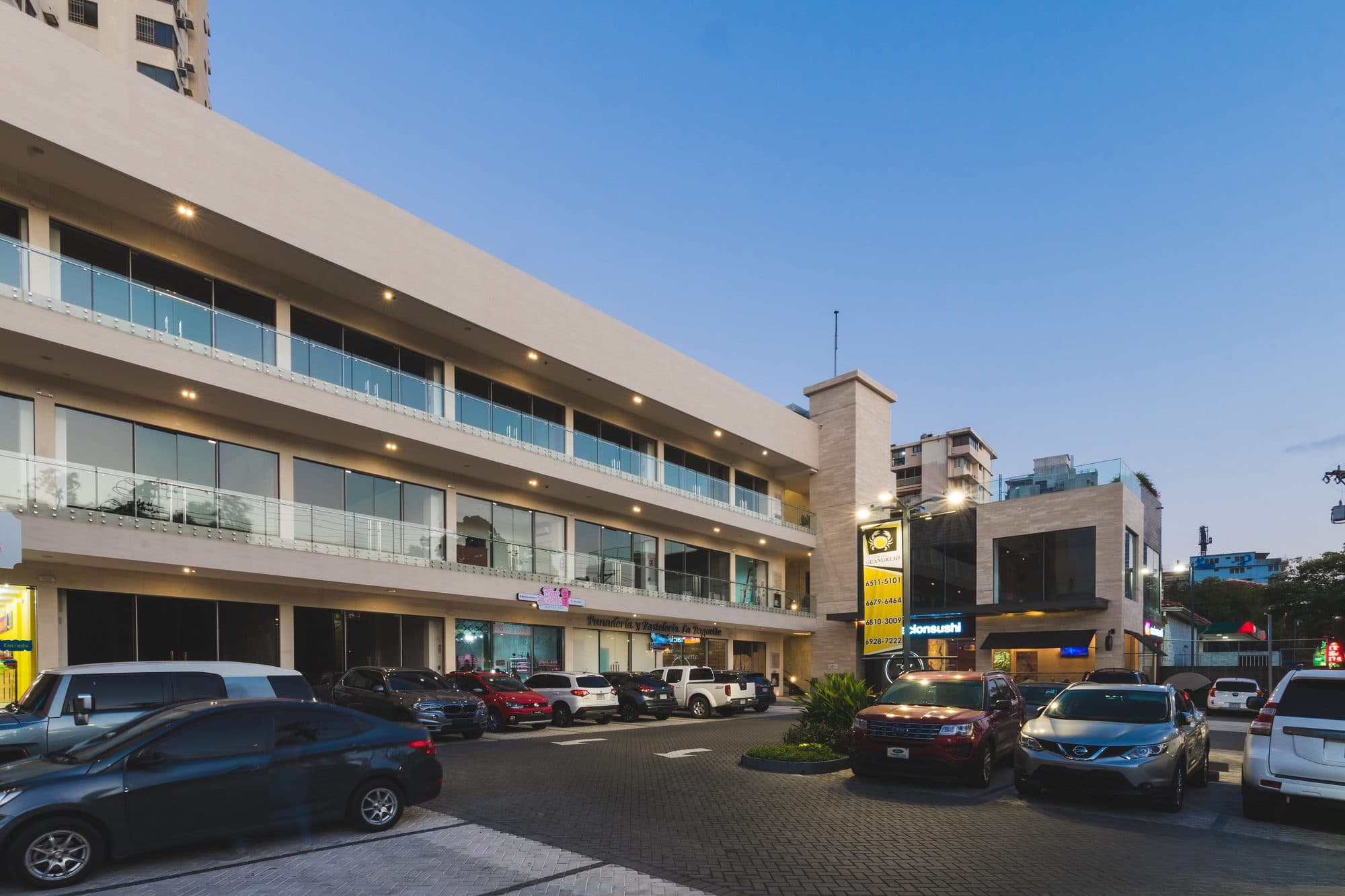 Plaza El Cangrejo retail building and front parking at dusk