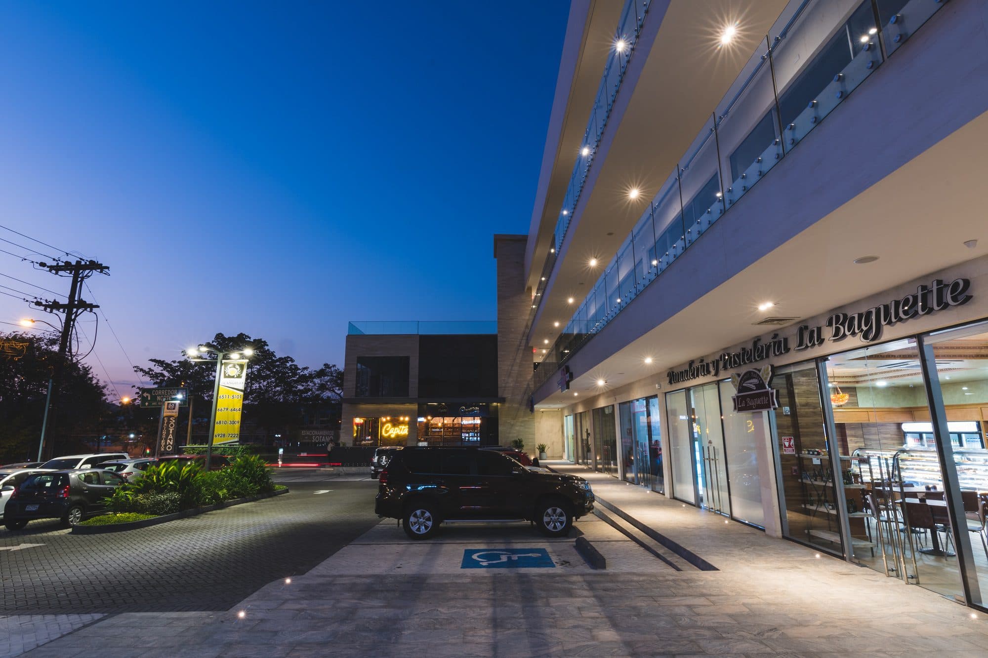 Ground-floor storefronts and parking along Plaza El Cangrejo