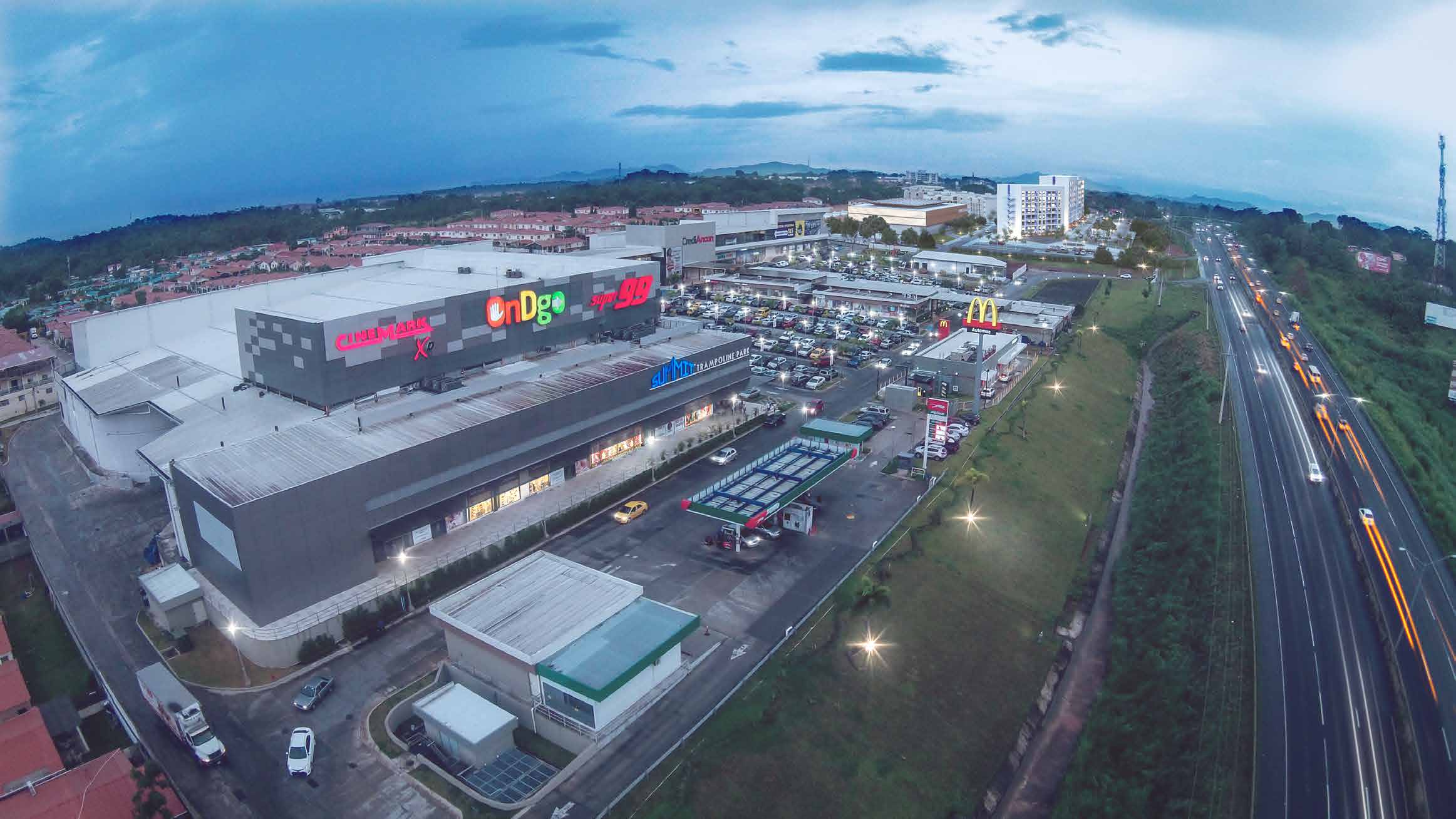 Aerial view of OnDgo Chorrera shopping plaza at dusk beside the Arraiján–La Chorrera highway