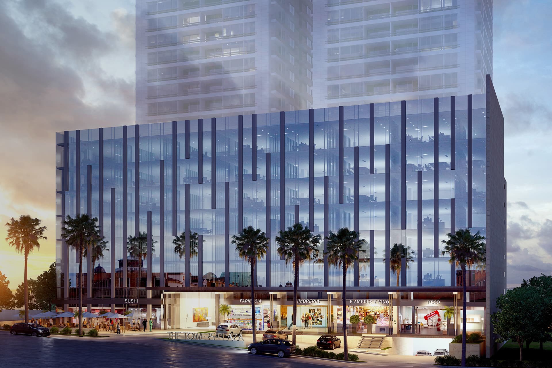The Towers Business Plaza glass office block and ground-floor shops at dusk