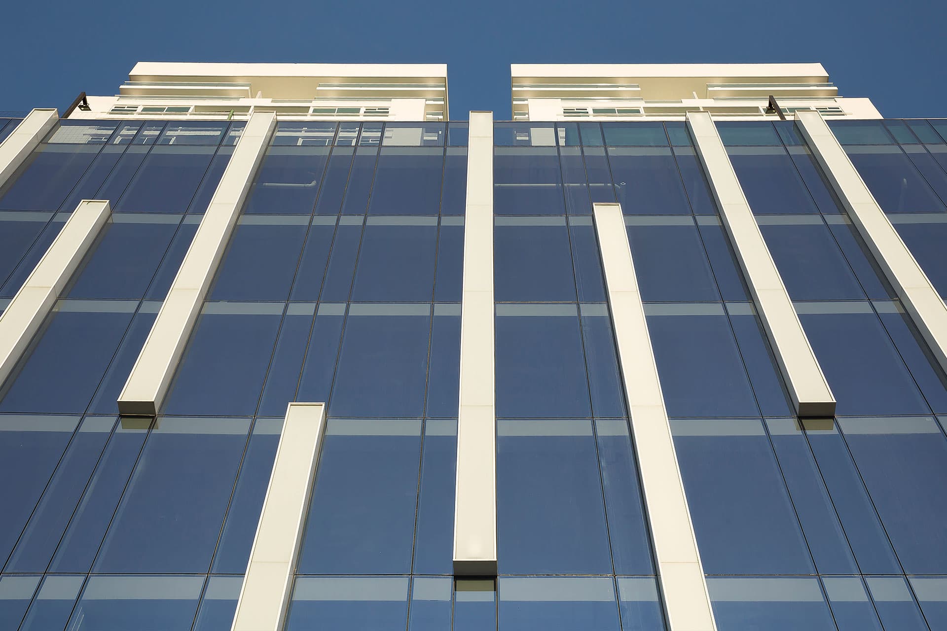 Vertical white fins on the glass curtain wall of The Towers Business Plaza