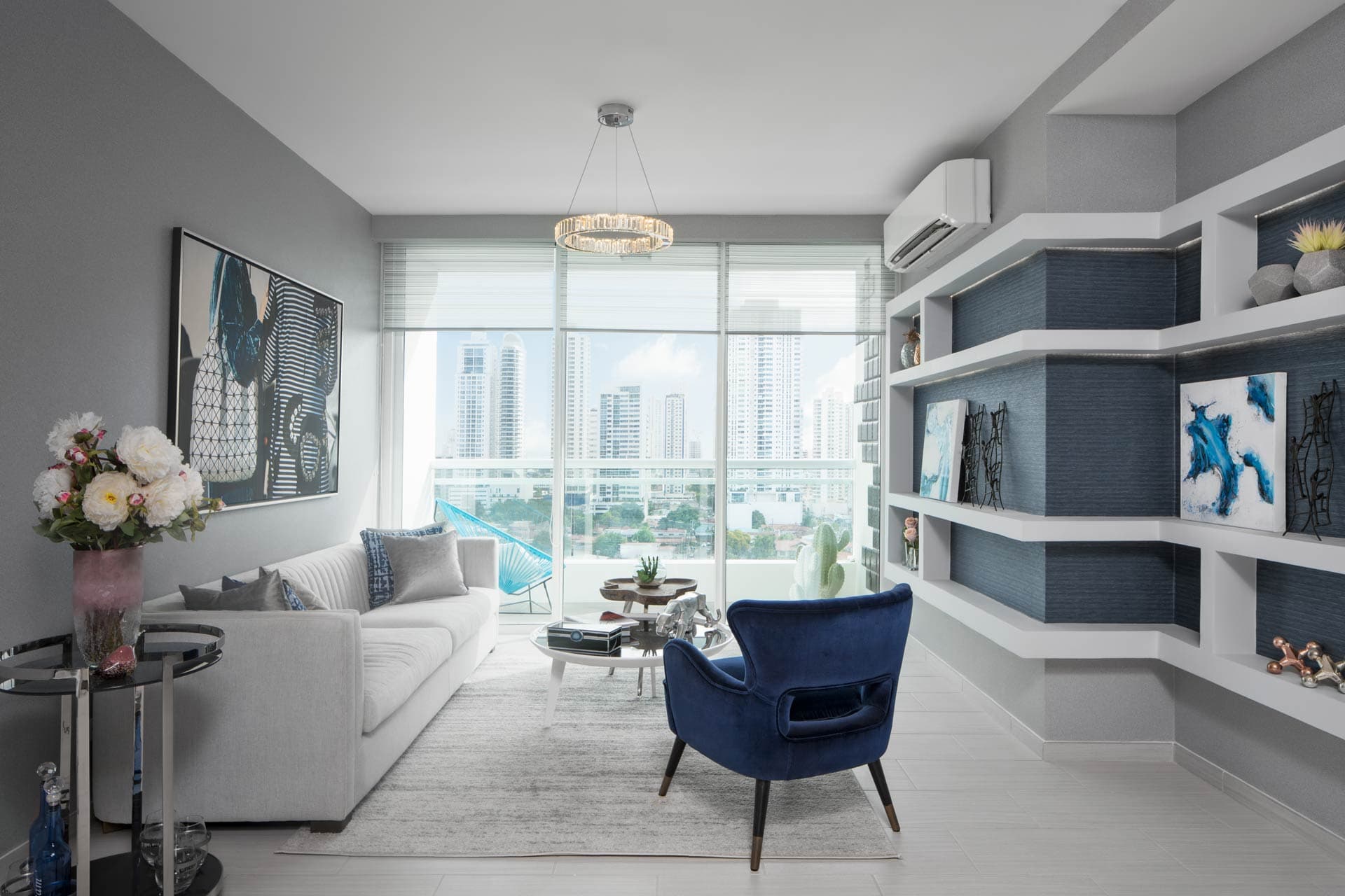 Living room with built-in shelving and city views in a The Towers Residences apartment