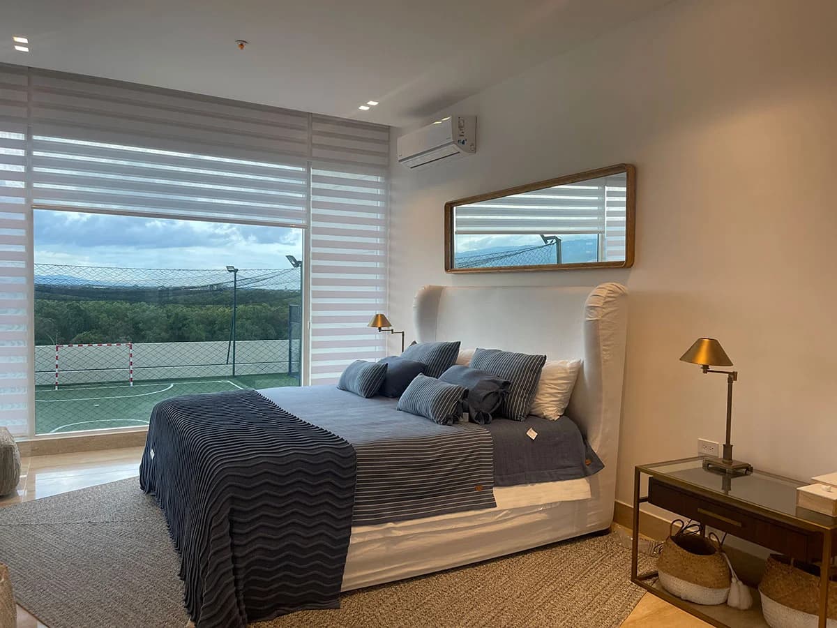 Bedroom with a wide window and tennis-court view in a Marea II apartment, Costa del Este