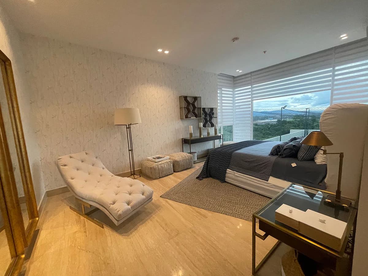 Master bedroom with a chaise longue and panoramic windows in a Marea II apartment, Costa del Este