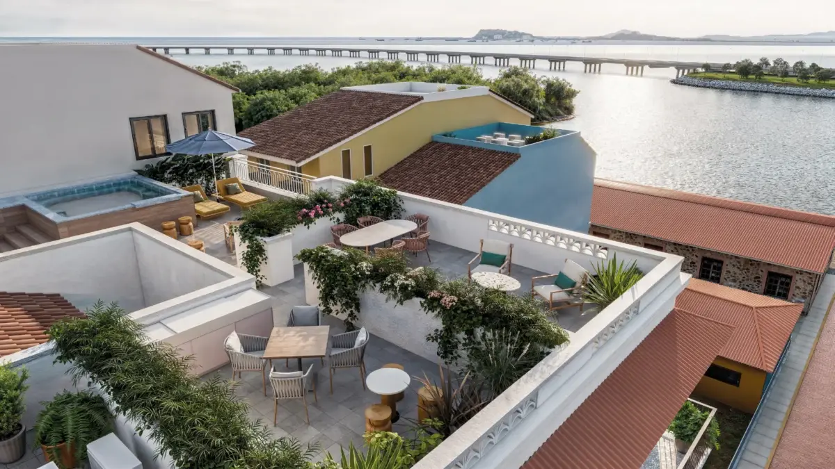 Aerial view of the Doña Ceci rooftop terrace with a small plunge pool, lounge seating and dining tables overlooking Casco Antiguo and the Bay of Panama