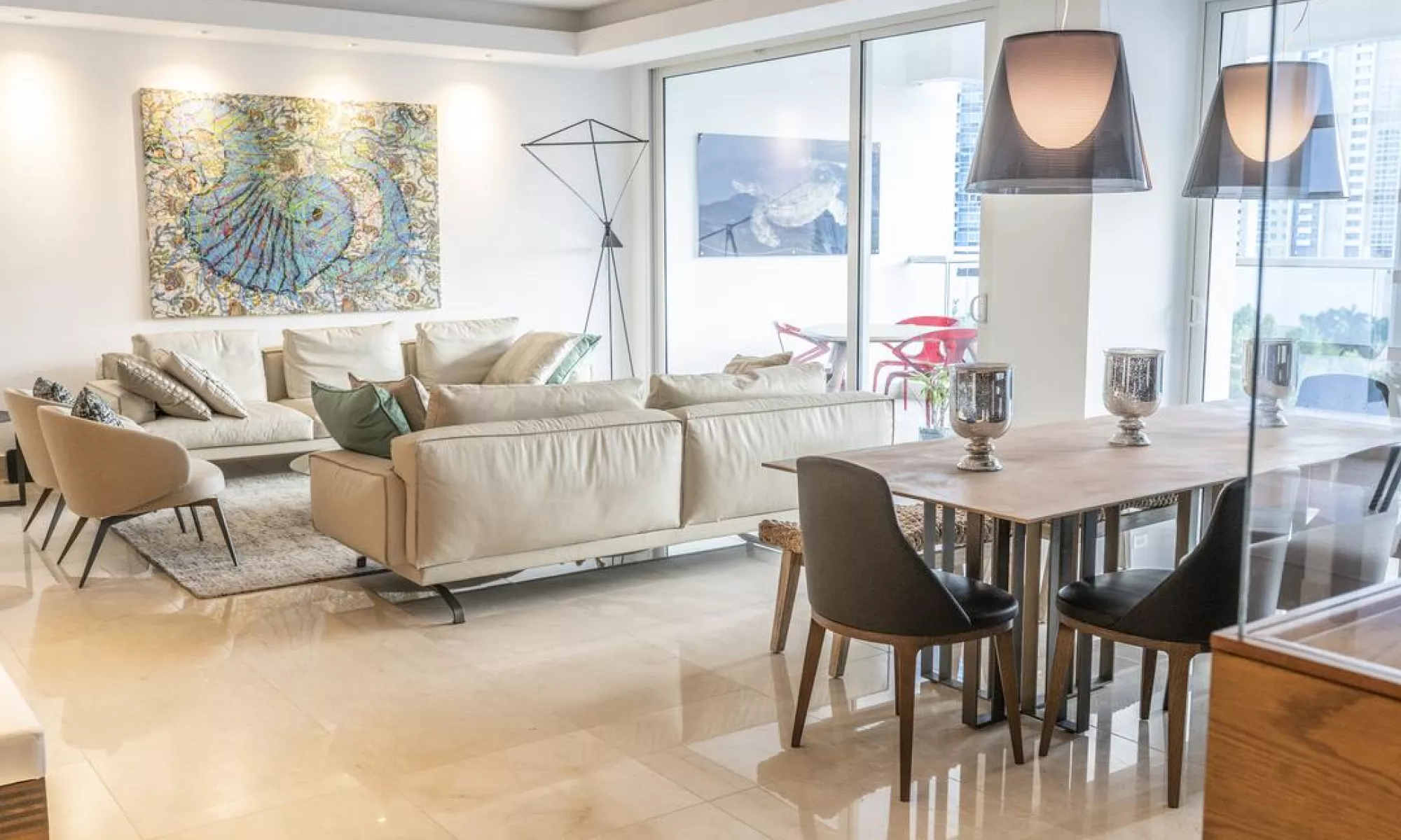 Bright living and dining room with marble floors and floor-to-ceiling windows in an Aria apartment, Costa del Este