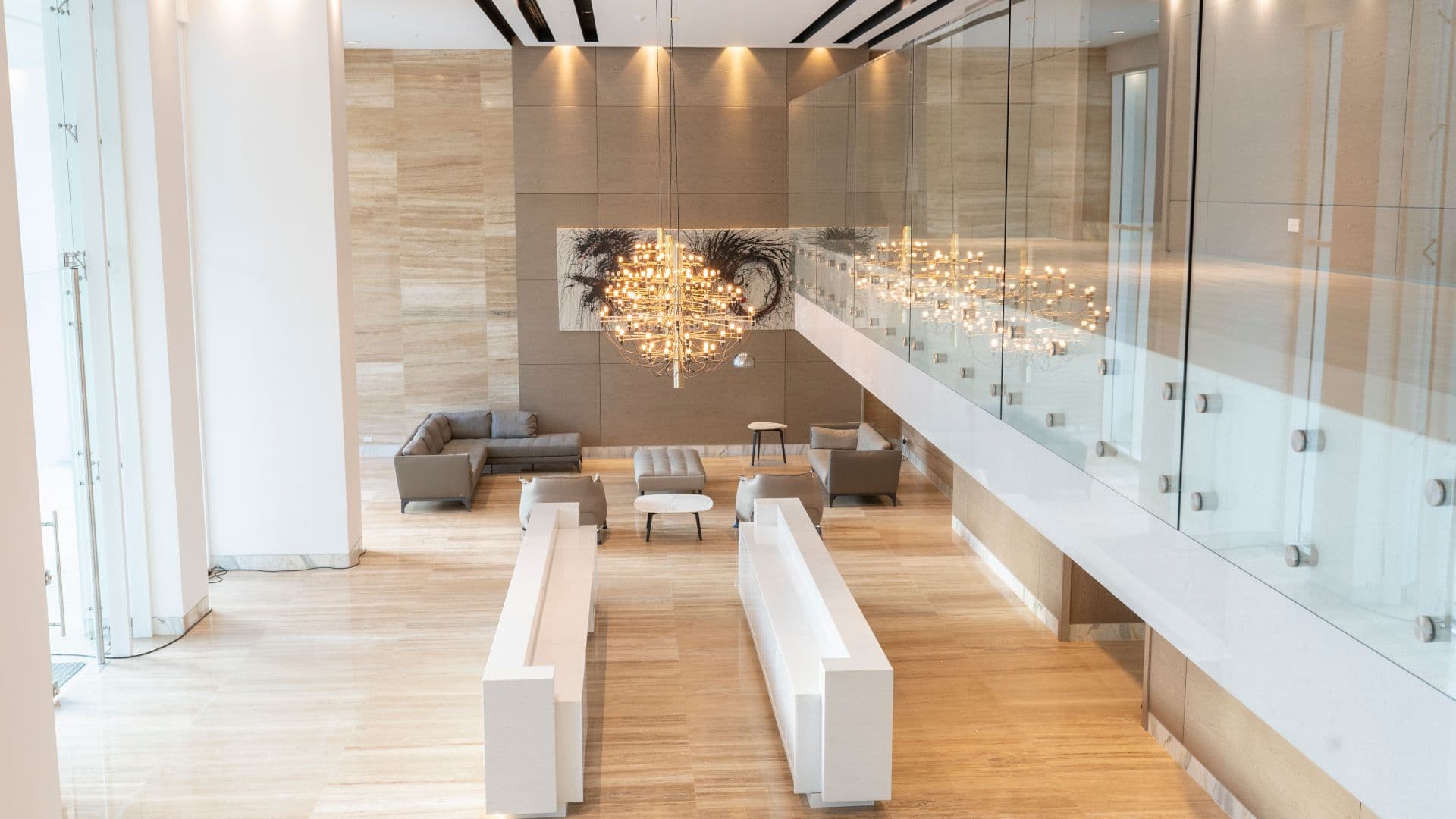 Aria lobby lounge with a glass-railed mezzanine, crystal chandeliers and white sofas