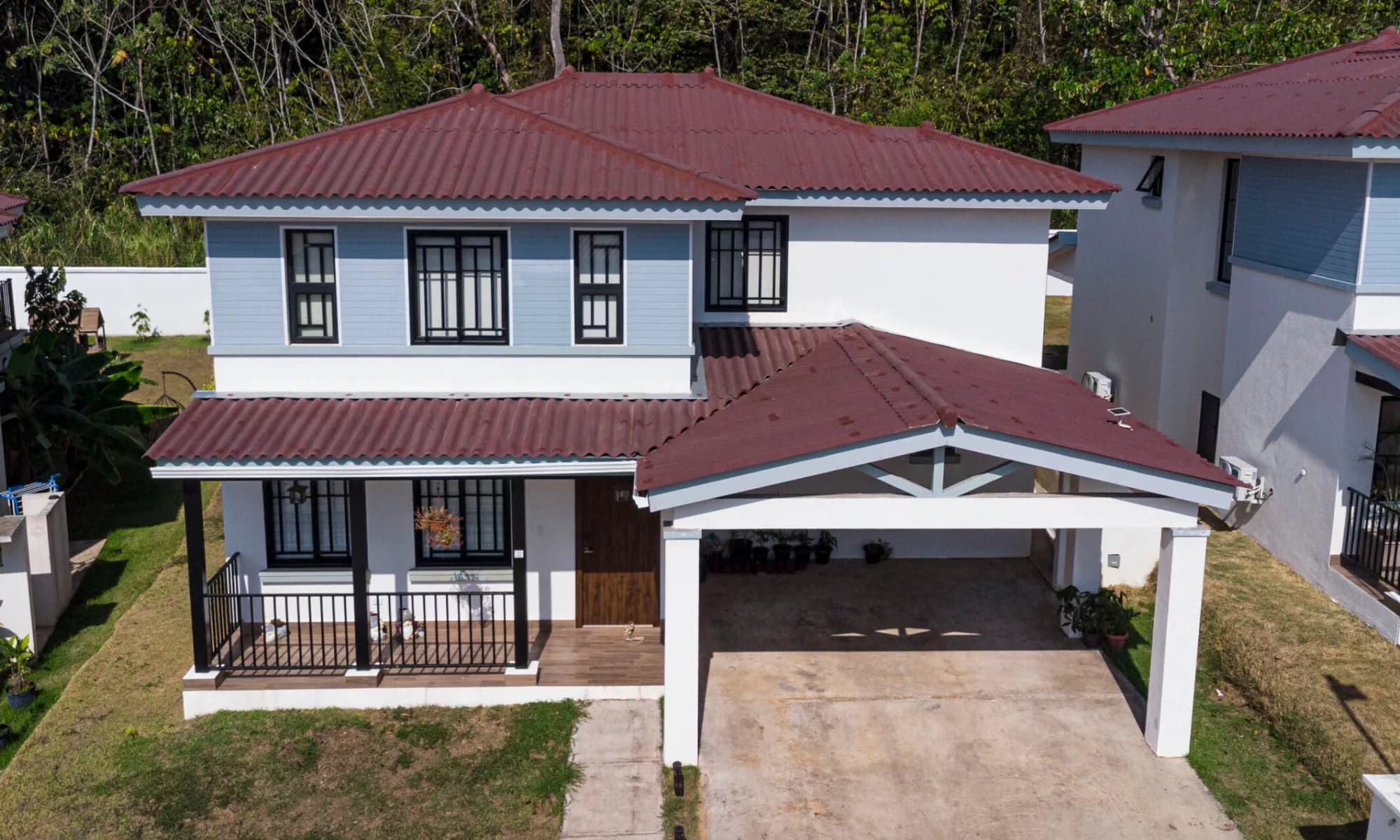 Two-storey Arcadia house with red roof, porch and carport in Costa Verde, Panamá Oeste