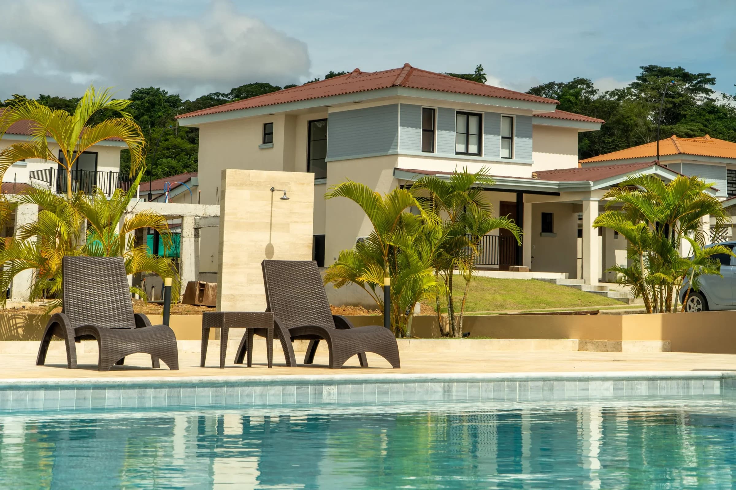 Arcadia community pool with loungers in front of finished two-storey homes in Costa Verde