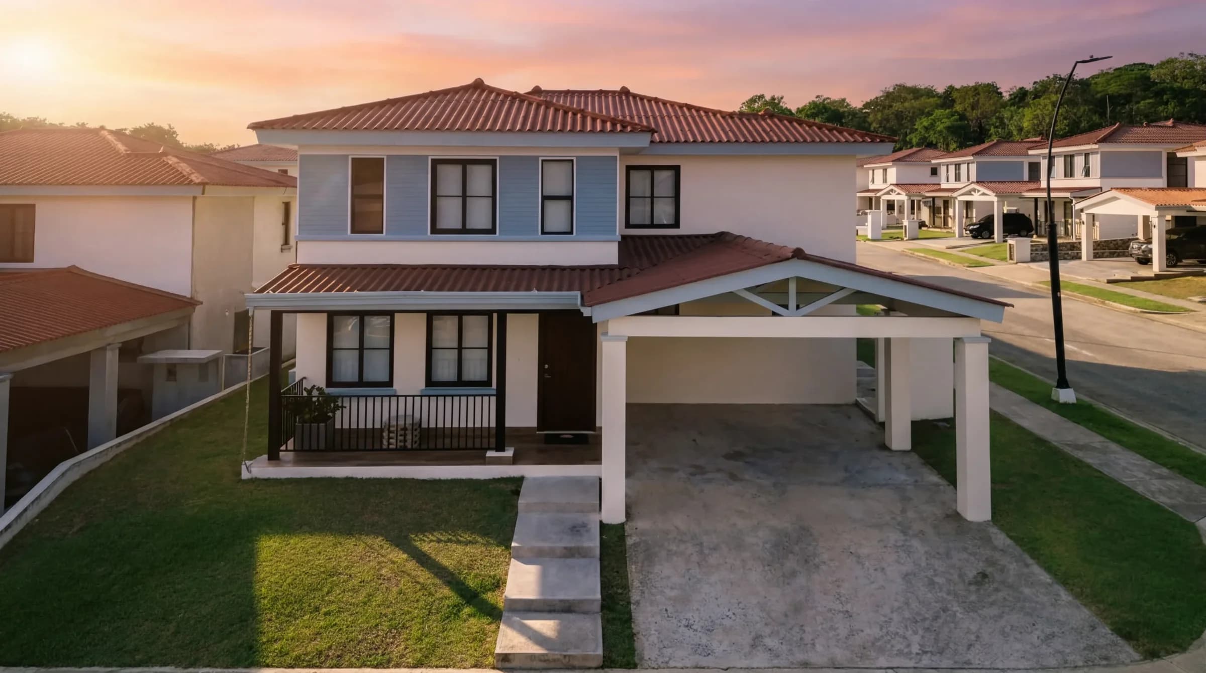 Two-storey Lilia model house with a red tile roof and carport at sunset in Arcadia, Costa Verde