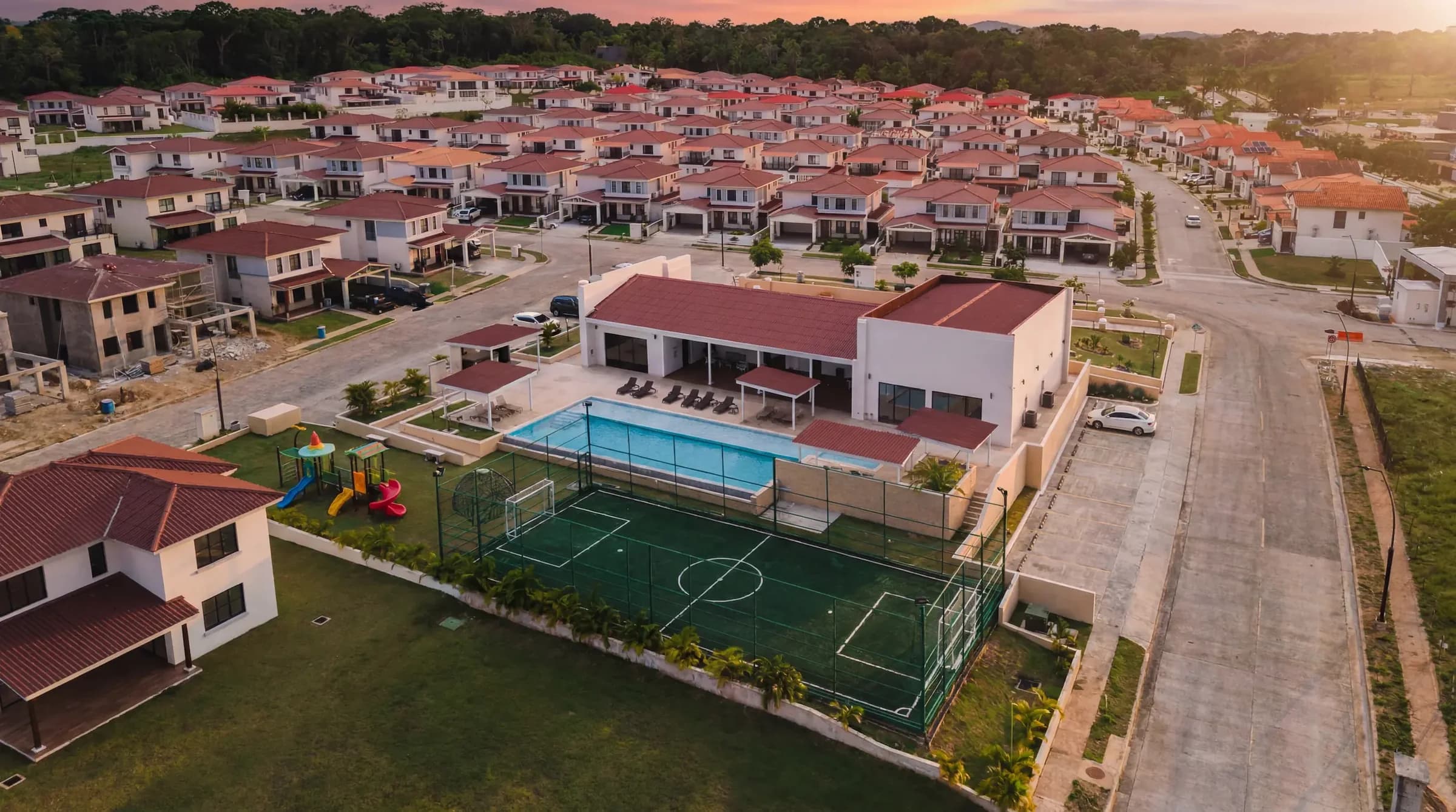 Aerial view of the Arcadia clubhouse with its pool, playground and sports court among the houses, Costa Verde