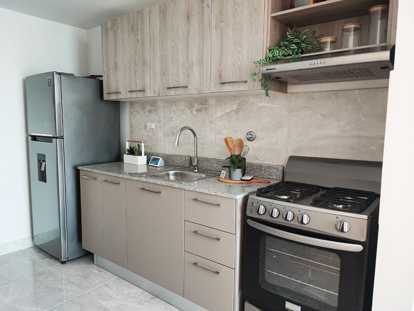 Kitchen with stainless steel appliances in an Época Parque Lefevre apartment