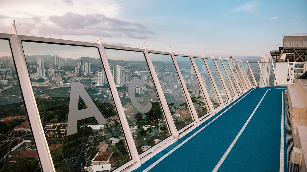 Glass-enclosed rooftop running track with city views at Victory Wellness