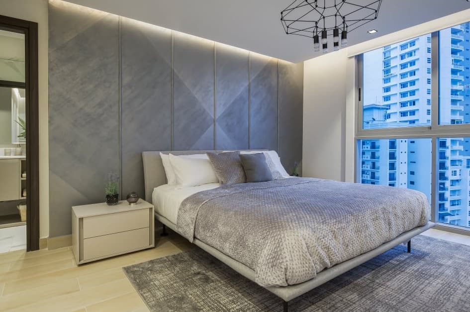 Bedroom with padded headboard wall and city views in a Vita apartment