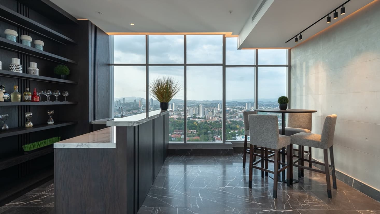 Bar counter with high stools and city views at Vita