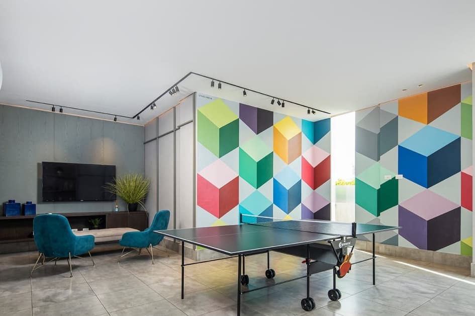 Game room with ping-pong table and geometric mural at Vita