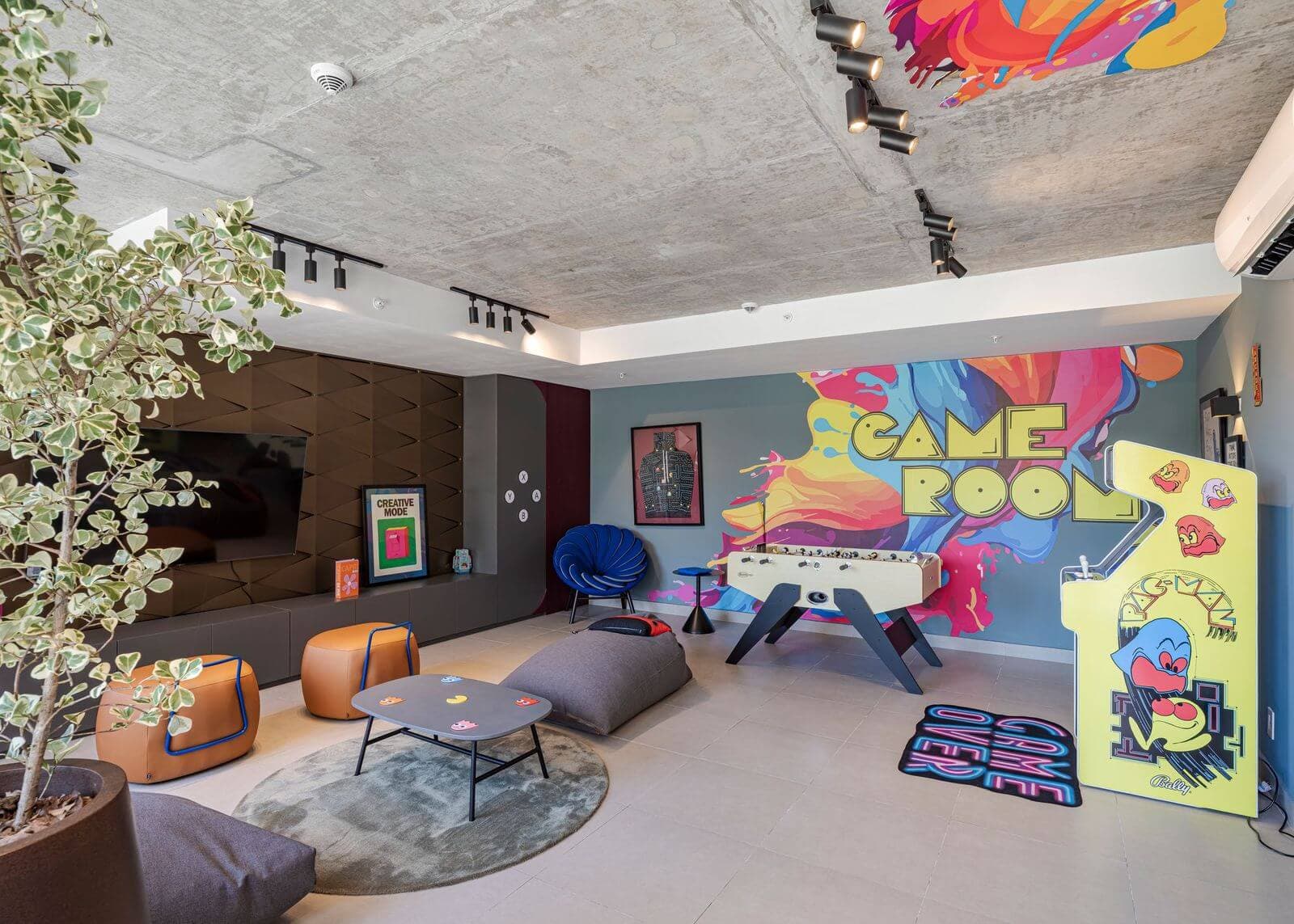 Game room with murals and a foosball table at Cëntriqo