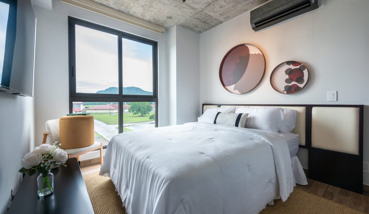 Bedroom with a window toward the hills in a Cëntriqo apartment