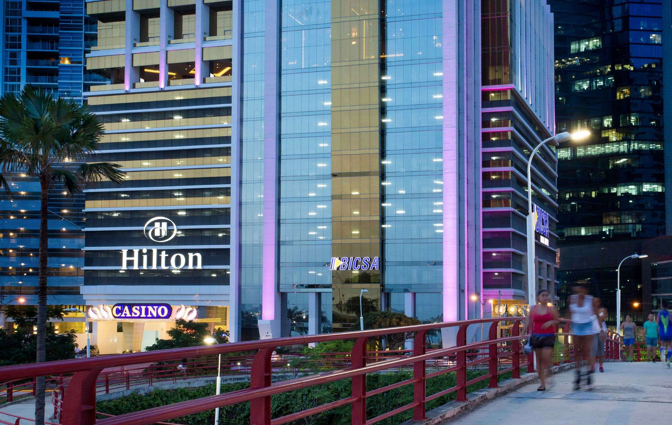 BICSA Financial Center at dusk with the Hilton sign and the pedestrian bridge on Avenida Balboa