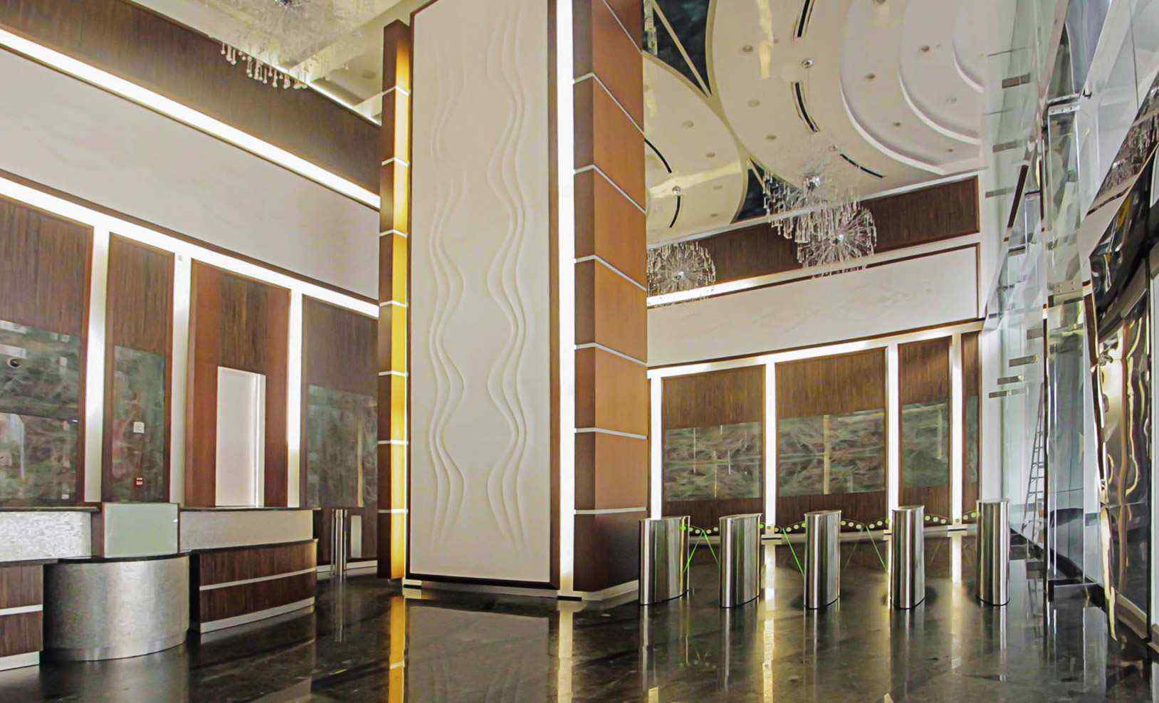 Lobby of BICSA Financial Center with wood-panelled walls, reception and access turnstiles
